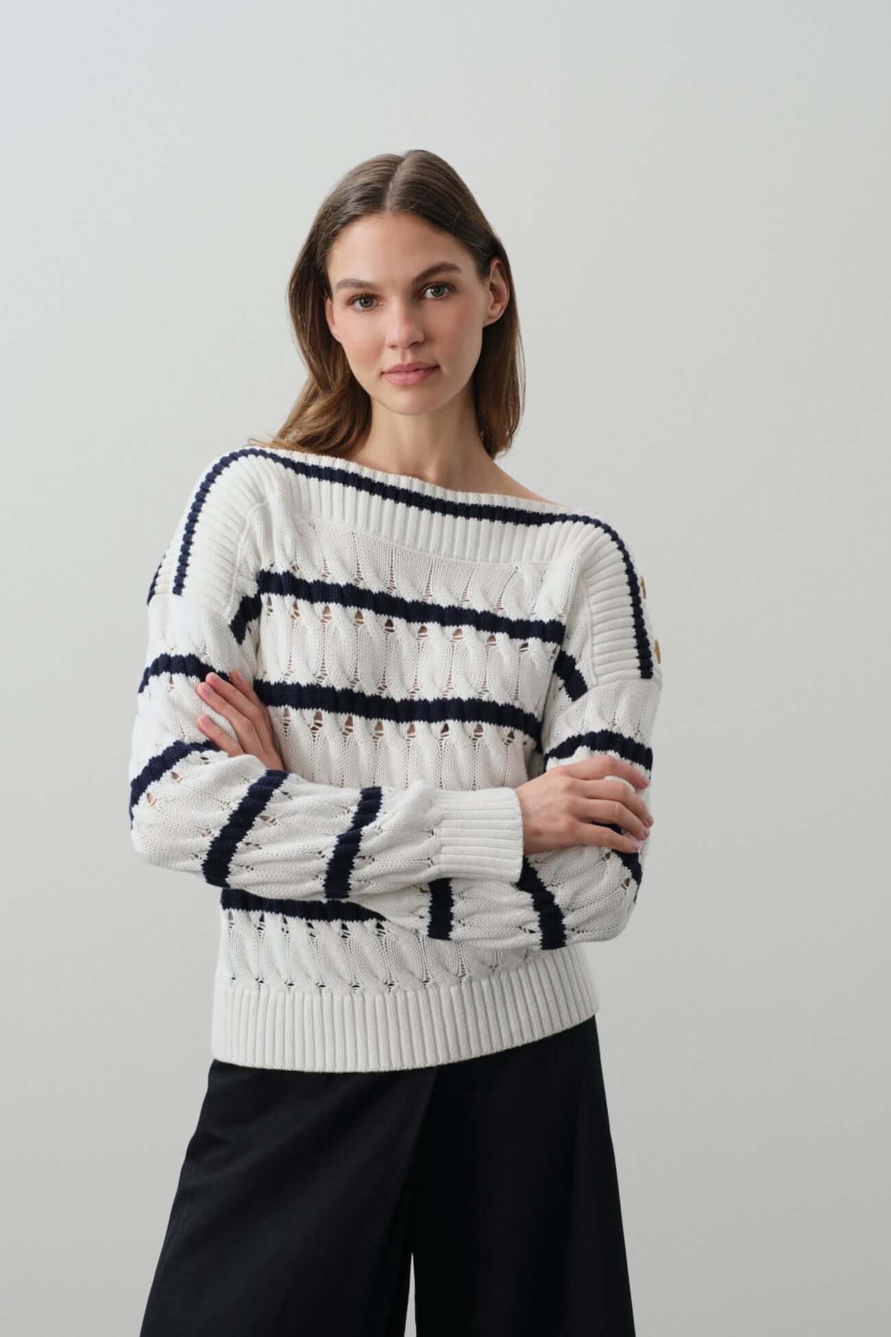 A model wearing a stylish white and navy striped sweater from the Sweaters collection.