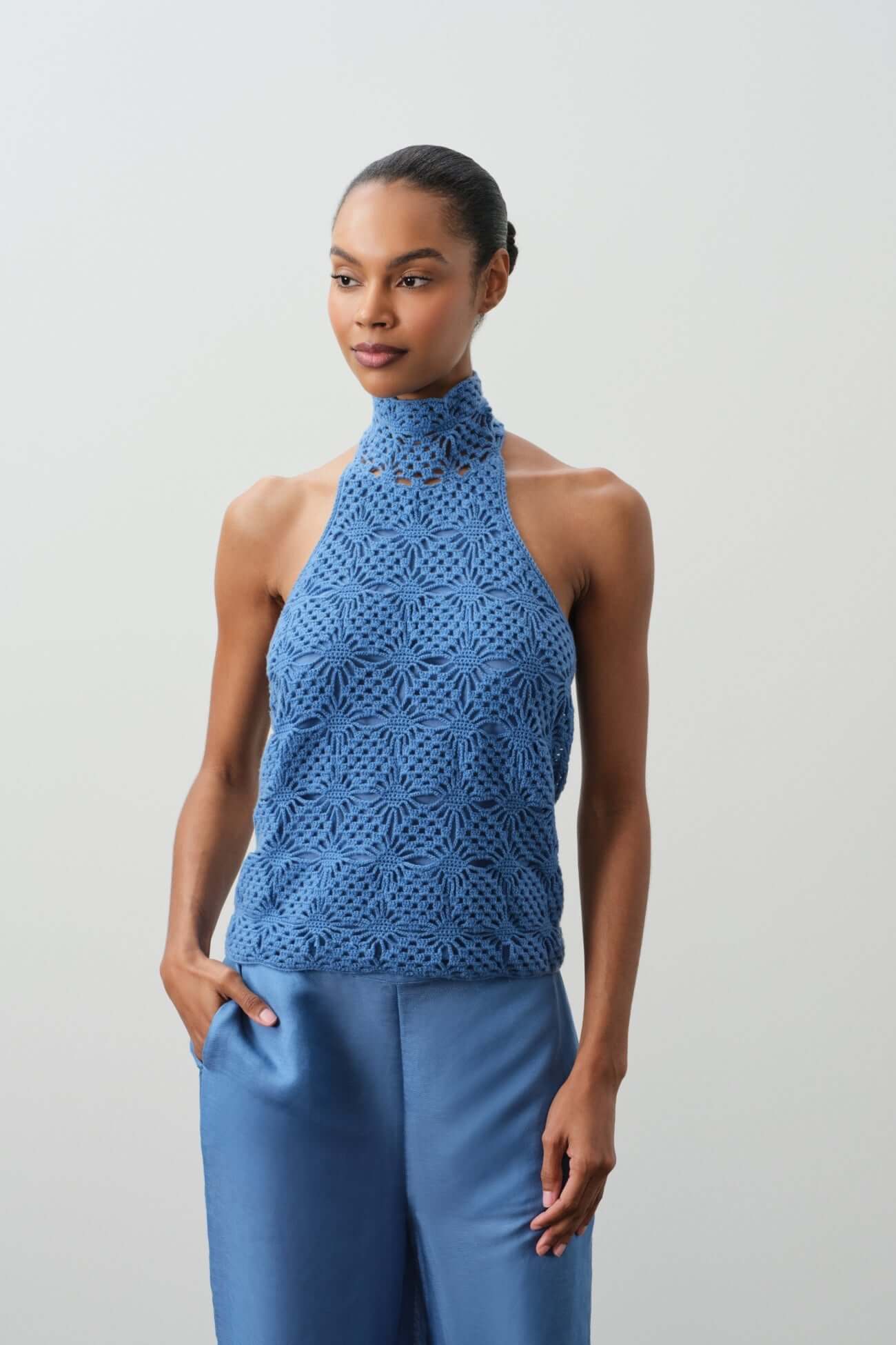Stylish blue crochet halter top from the Tops collection, perfect for summer wear.