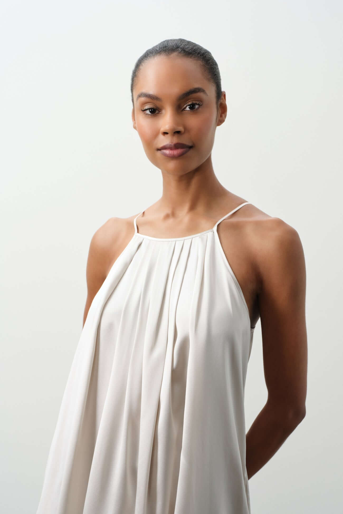 Elegant woman wearing a simple dress in soft fabric, showcasing the beauty of Dresses collection.